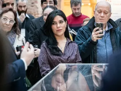 Mujer de cabello largo con blusa púrpura en un evento público