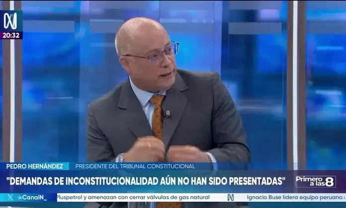 Hombre rubio con traje en un entorno formal junto a una boleta electoral con los nombres de Donald J. Trump y Joe Biden